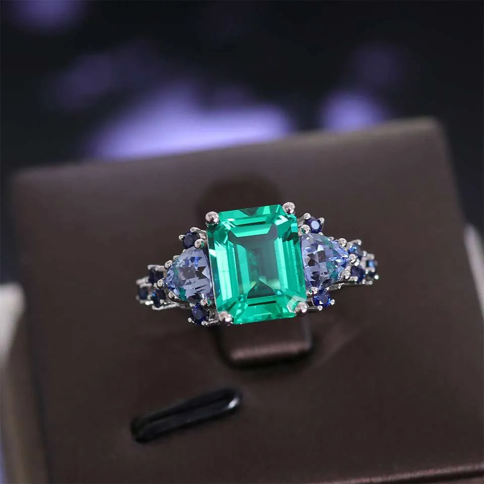 10K-18K , Emerald Ring With Trillion Sapphires And Dark-Colored Rounds